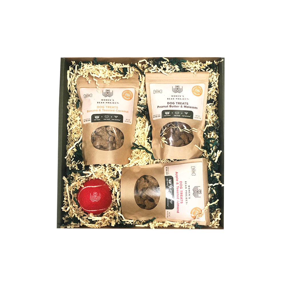 Box of various kinds of Women's Bean Project dog treats, with a Women's Bean Project monogramed tennis ball