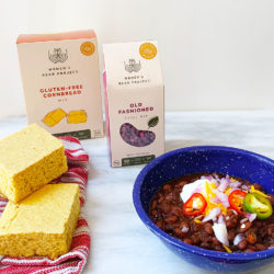 Women's Bean Project gluten-free cornbread and chili set behind a prepared version of the meal.