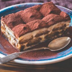 Women's Bean Project French Roast Whole Bean Coffee Tiramisu on a plate next to a spoon.