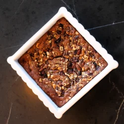 A white pan of Ginger Zing Brownies using Women's Bean Project Ginger Zing Trail Mix and Brownie Mix.